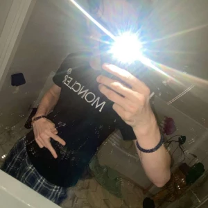 Svart t-shirt från Moncler - Snygg svart t-shirt från Moncler med deras ikoniska logga på bröstet. Perfekt för en stilren look. Om det är något du undrar över är det bara att skriva