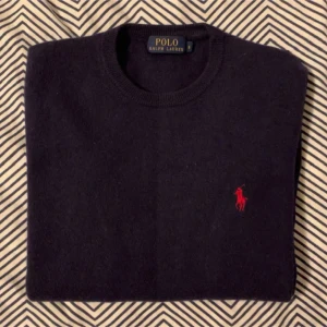 100% Merinoull Polo Ralph Lauren tröja Xs/S - Säljer en stilren mörkblå merinoull tröja från Polo Ralph Lauren med det klassiska röda logotypen på bröstet. Tröjan har långa ärmar och en rund halsringning, perfekt för en avslappnad men snygg look. Tröjan är i storlek S men har krymt lite i tvätten och passar snarare xs. Priset kan diskuteras. Mvh Hannes.