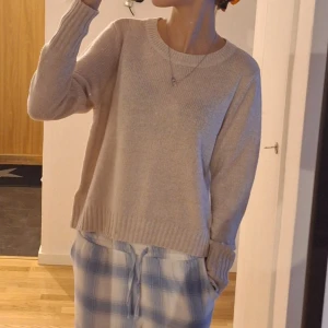 Stickad tröja - Mysig beige stickad tröja med rund hals och långa ärmar. Perfekt för kyligare dagar och enkel att matcha med olika outfits. Den är I storlek M men är som S