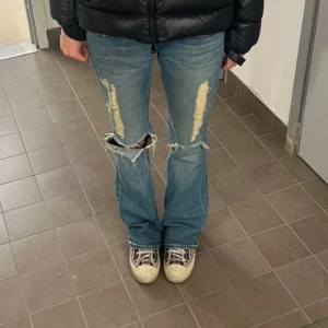 Blå bootcut jeans med slitningar - Snygga blå bootcut jeans med slitningar ifrån True Religion.  Går ej att köpa