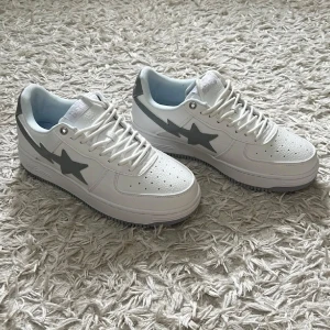 Bapestas x JJJOUND vita sneakers  - Helt nya, aldrig använda, inga creases, har kvar påsen och alla originella lapparna de kom med. Det medföljdes även ett par creasprotectors och en dustbag som medföljer vid köp. De är originella och har tyvärr inte kvittot. Däremot är de helt oanvända, gjorda av ett extremt mjuk läder, väldigt bekväma skor- passar med alla färger. Pris kan diskuteras. Nypris ~5500 kr. 