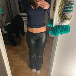 Svarta skinnbyxor - Snygga svarta skinnbyxor med medelhög midja som kan vikas ner till lågmidjat utan att det ser skumt ut, så som jag använt de. 