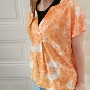 Orange och vit blus med mönster - Säljer en snygg blus i orange och vitt med ett unikt mönster. Blusen har en v-ringad design och korta ärmar, perfekt för en avslappnad stil. Passar bra till jeans eller kjol för en somrig look. Materialet är polyester❤️