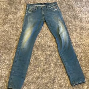 Blå jeans från Replay - Snygga blå jeans från Replay med en klassisk femficksdesign. De har en diskret tvättad look och är i modellen Anbass. Perfekta för en avslappnad stil. Storlek W32 L36 men passar mer som L34.