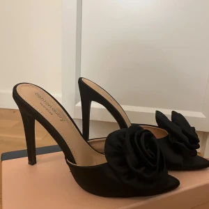 Svarta klackskor med ros - Svarta högklackar från Ashton Aubry. Endast använda en gång. Orginalbox tillkommer 