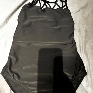 Svart baddräkt med snörning - Snygg svart baddräkt med trendig snörning i ryggen.