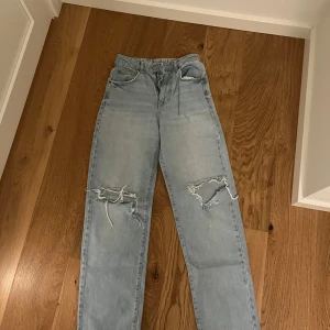 Ljusa jeans med slitningar - Säljer ett par ljusa jeans med slitningar på framsidan. De har en straight passform och är i storlek W26 L32. Det enda är att slitningarna är lite extra slitna från när jag köpte dem.