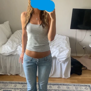 Ljusblå jeans med bootcut - Säljer ett par ljusblå jeans med bootcut-stil. De har en klassisk femficksdesign och är perfekta för en avslappnad look. Midjan är låg och jeansen har en snygg tvättad finish. 🩷 midja rakt över: 36 innerbenslängd: 78