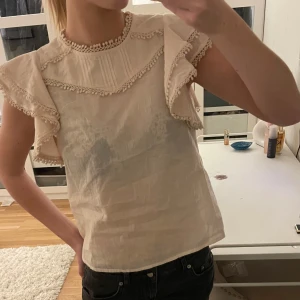 blus med volangdetaljer - Säljer en söt beige blus med volangdetaljer på ärmarna🩷Blusen är ganska luftig och lite genomskinlig i materialet!