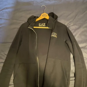 Emperio Armani tröja s - En svart/guld dragkedja från Emperio Armani. Den är i bra skick och är köpt från NK. 