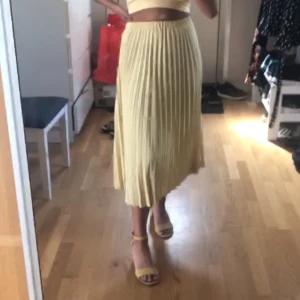  Plecerad gul kjol från Gina - Gul plecerad kjol från gina.  I storlek 36 En liten liten fondation fläck påvens sidan. 