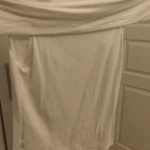 Vit offshoulder topp - Säljer en stilren vit offshoulder topp. Perfekt för sommardagar eller en kväll ute. Toppen är i ett mjukt och bekvämt material, vilket gör den både snygg och skön att bära. Passar bra till både jeans och kjol, bara testat!