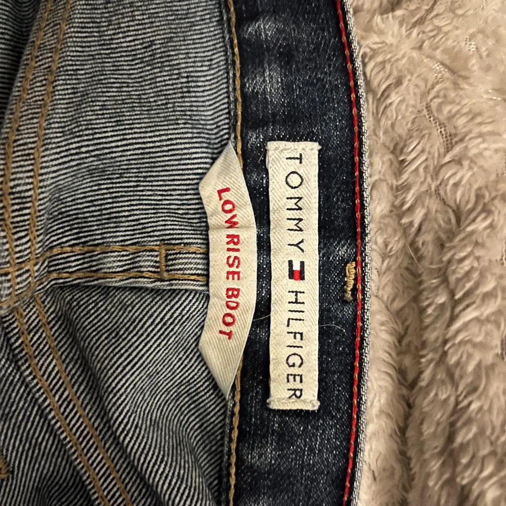 Lågmidjade mörkblåa utsvängda jeans från Tommy Hilfiger.  Storlek 8 vilket motsvarar 36/38. Är 165 som referens!! (Står på tå i bilderna för att få med hela jeansen på bild) så om du är något längre än mig så kommer det fortfarande vara långa🩷. Jeans & Byxor.