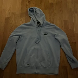 Lacoste hoodie - Denna lacoste hoodie används ej och är i okej skick, det finns en liten fläck men som knapt syns i vardagen när man har på den