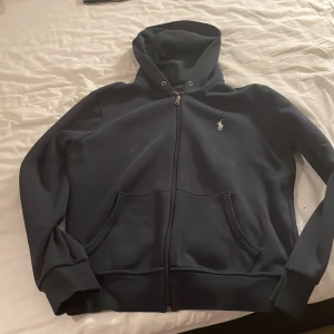 Polo Ralph lauren Hoodie blå med dragkedja - Varan e änvönd några gånger men fortfarande bra skick utan några synliga skador och slitningar
