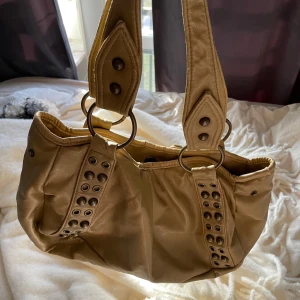 Supersnygg väska - En snygg vintage väska men fina guld detaljer, några slitningar som man kan se på bilderna men annars i bra skick, får plats med skoldator så att den sticker upp💗