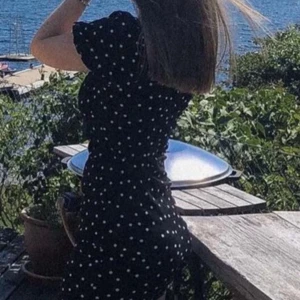 Svart prickig klänning - Säljer en superfin svart klänning med vita prickar. Den har korta puffärmar och en smickrande passform som är perfekt för sommardagar. Klänningen är i bra skick och passar både till vardags och fest. Perfekt för en dag vid havet eller en somrig picknick! 🌞