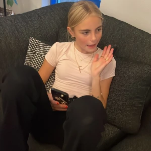 Ljusrosa kortärmad topp - Säljer en söt ljusrosa kortärmad topp i mjukt material. Perfekt för vardagsbruk eller en avslappnad dag ute. Toppen har en enkel och stilren design som gör den lätt att matcha med olika outfits.