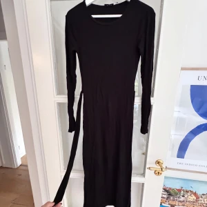 Ribbad klänning  - Ribbad klänning från NAKD i storlek S. Sparsamt använd. Lång, går ner till vaden på mig som är 176. Har knytband i sidan. 