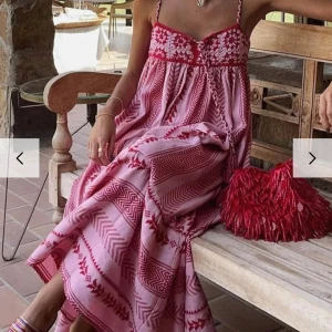Långklänning  - Säljer en superfin rosa och röd långklänning med smala axelband och  vackert mönster. Avslappnad passform och gjord i ett lätt och skönt material. Den har också en söt knytning framtill som ger extra charm. Säljer pågrund av fel storlek, lapp kvar. 💗