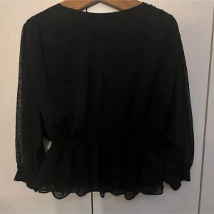 Svart blus - Jätte fin blus som är är köpt här på Plick. Säljes då den var för kort i armarna för mig 