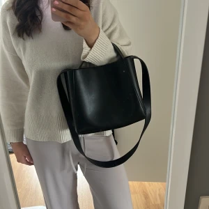 Svart axelväska i skinn - Snygg svart axelväska i skinn med minimalistisk design. Det långa bandet går att ta av och sätta på. ❣️❣️