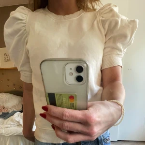 Vit topp med puffärmar - Säljer en snygg cremevir topp med puffiga kortärmar och ribbade kanter. Super söt till jeans eller kjol. Storleken är M men skulle säga att den är mer som en S.  Hör av dig om du har borga frågor💕