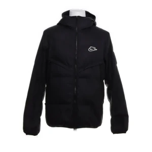 Svart pufferjacka från Nike - Säljer en svart pufferjacka från Nike med huva och dragkedja. Jackan har ett stilrent Nike-märke på bröstet och är tillverkad i 100% polyester. Perfekt för kyligare dagar med sin vadderade design.