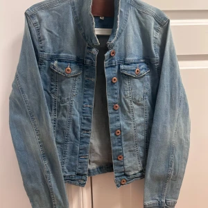 Blå jeansjacka - Snygg blå jeansjacka från Lager 157 . Jackan har knappar framtill och två bröstfickor med knappstängning. Perfekt för en avslappnad stil. Dock skulle jag tyvärr inte säga att jackan är i XL, mer åt S/M