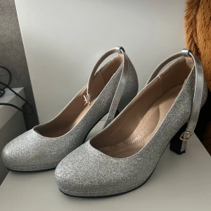 Glittriga silverklackskor - Medium klack, silver och glittrig.