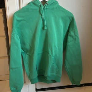 Grön hoodie från bikbok - Säljer en grön lite oversized hoodie från bikok. Jättemysig och varm. Den är pyttelite nopprig med går säkert att få bort. Säljer även en likadan fast blå😊