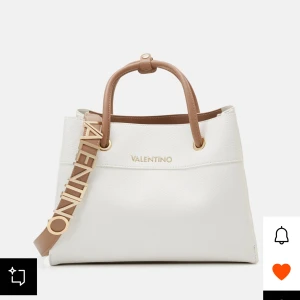 Vit handväska från Valentino(orginal emballage ej upppackad)  - Snygg helt ny vit handväska från Valentino med bruna detaljer och justerbar axelrem. Väskan har ett stilrent utseende med guldfärgade metalldetaljer och en praktisk dragkedja. Perfekt för att ge din outfit en lyxig touch.