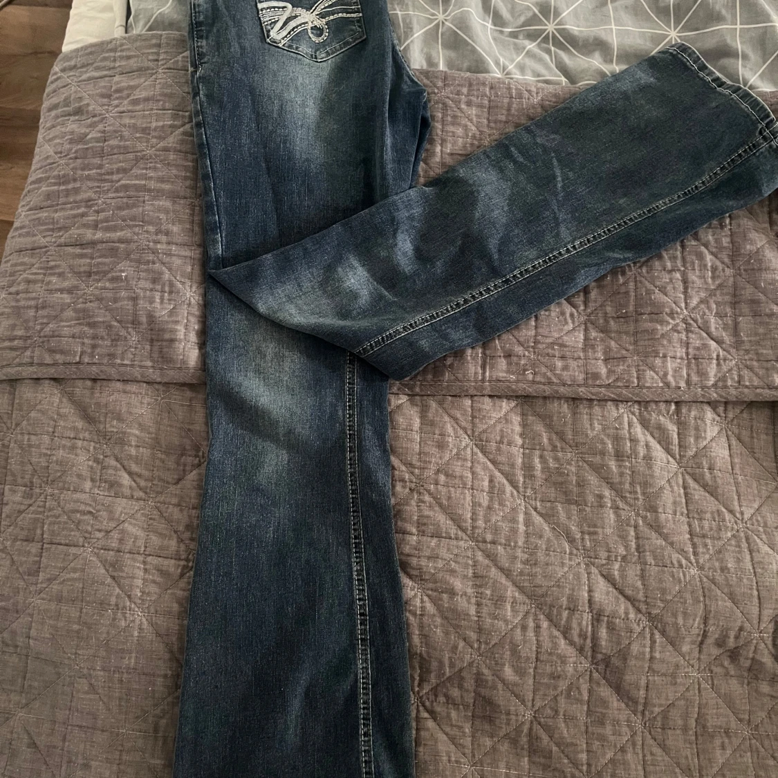 Blå jeans med broderade bakfickor