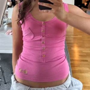 Rosa linne från Dolce & Gabbana💓 - Säljer en snygg rosa linnetopp från Dolce & Gabbana med knappar framtill och en liten ficka på bröstet. Toppen har ett D&G-märke i guld längst ned💕