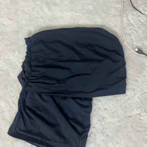 Mörkblå topp från zara - Snygg mörkblå topp från zara. Den har en ärm och är off shoulder. Perfekt för att skapa en stilren look. Toppen är enkel och elegant, vilket gör den lätt att matcha med olika kjolar och accessoarer. Säljer då den inte kommer till användning! Jättesnygg och trendig💕 storlek M men passar mig med Xs/S