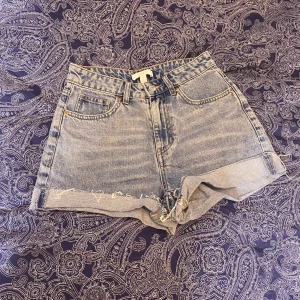 Korta blå jeansshorts - Snygga blå jeansshorts med klassisk femficksdesign. Perfekta för en avslappnad stil. De har en hög midja.