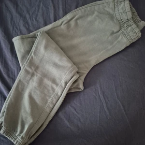 Gröna mjukisbyxor med resårmidja - Säljer ett par bekväma gröna mjukisbyxor med resår i midjan och vid bensluten. Perfekta för en avslappnad dag hemma eller en promenad i parken. Byxorna har en loose passform som ger extra komfort.