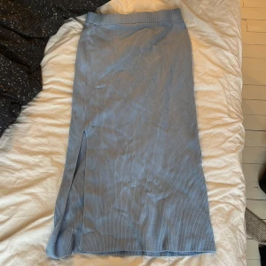 Blå ribbad kjol från H&M Divided - Snygg blå ribbad långkjol från H&M Divided med en stilren slits på sidan. Perfekt för en avslappnad och trendig look. Tillverkad i en mjuk och bekväm materialblandning.💕Använd fåtal gånger. Se liten defekt på baksidan, sista bilden, denna defekt syns dock inte💕
