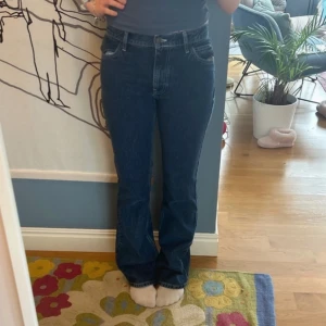 Blå jeans från Asos - Säljer ett par snygga blå jeans från Collusion. De har en bootcut-stil och är högmidjade, vilket ger en trendig look. Perfekta för dig som vill ha en klassisk jeansstil med en modern twist.
