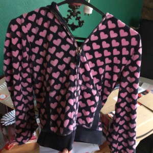 Rosa hoodie med hjärtan från GapKids - Säljer en söt rosa hoodie från GapKids med ett hjärtmönster i rött. Den har dragkedja framtill och långa ärmar. Samma märke som den som visas i Jennifers Body. Svarta version 