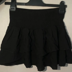 Svart volangkjol - ❗️TAR ENDAST EMOT SWISH, skriv t mig vid köp ❗️ Snygg svart kortkjol med volanger och elastisk midja. Använd nån gång. 🖤