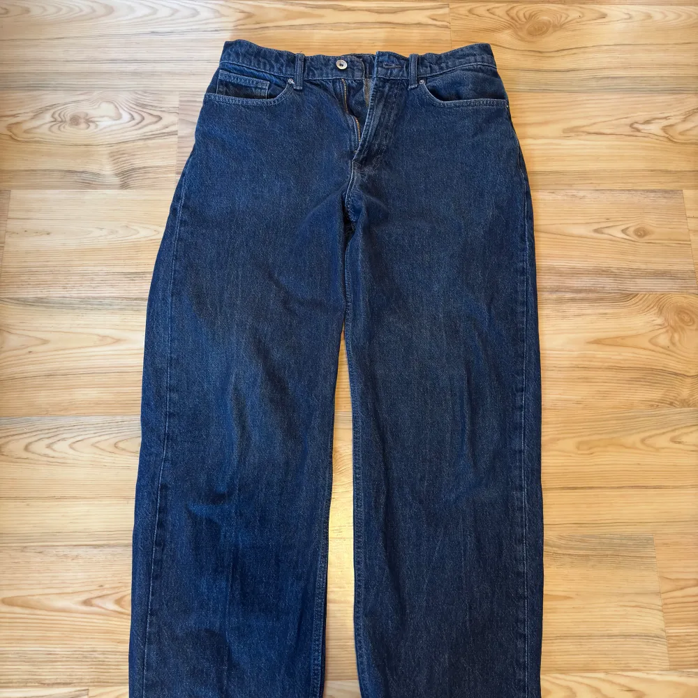 Snygga blå jeansbyxor med klassisk design och fem fickor. Byxorna har en rak passform och är perfekta för en avslappnad stil. De har en knapp och dragkedja framtill.. Farkut & Housut.