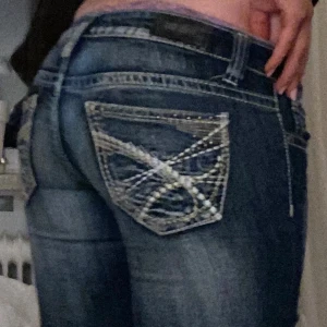 Blå jeans med slitna detaljer - As snygga lågmidjade bootcut jeans. Dom är i storlek 34 men skulle säga att de passar även som 36. Säljs pga att jag inte använder dom längre. Pris kan diskuteras💕