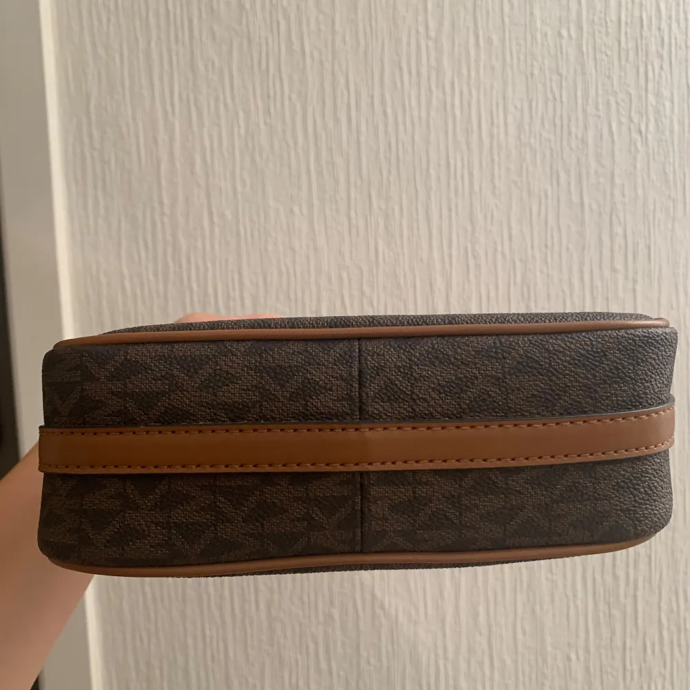 Brun liten handväska med guldfärgade detaljer från Michael kors. Knappt använd, i nytt skick.. Väskor.