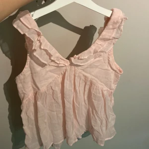 Rosa blus -  Ljus rosa blus köpt på Gina Trickot men aldrig använd💕Går att justera lite själv hur den ska sitta då man knyter den i ryggen