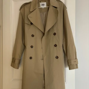 Trenchcoat från Twist and Tango - Säljer denna fina trenchcoat från Twist and Tango då den inte kommer till användning. Den är inköpt förra året och har bara används ett fåtal gånger därav inga fläckar eller annat. 