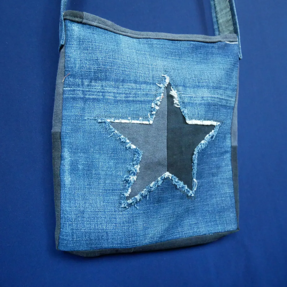 Blandade material, främst denim 100% återbruk Storlek: ca 27x24cm Band: ca 84cm Dragkedja: Nej Effekt: fet swag på stan. Väskor.