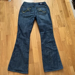 Rock & republic lågmidjade jeans - Säljer ett par lågmidjade utsvängda jeans från Rock & Republic. De är för långa på mig som är 155cm lång. Står ingen storlek tyvärr men passar S. De är insydda i midjan men syns inte med dem på. ☺️Innerbenslängd: 79cm midjemått: 36cm
