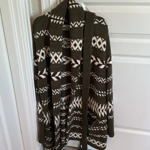 Ralph Lauren kofta - Säljer en mysig kofta i grönt med vitt mönster. Koftan har långa ärmar och ett knytband i midjan. Perfekt för kyliga dagar!