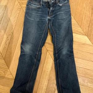 Blå jeans från Acne - Snygga blå jeans från Acne med klassisk design och dragkedja. Perfekta för en avslappnad stil. De har en normal passform och är tillverkade i slitstarkt denim.